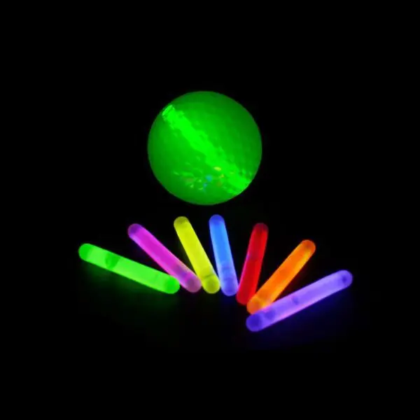 A group of glow sticks in front of a green ball.