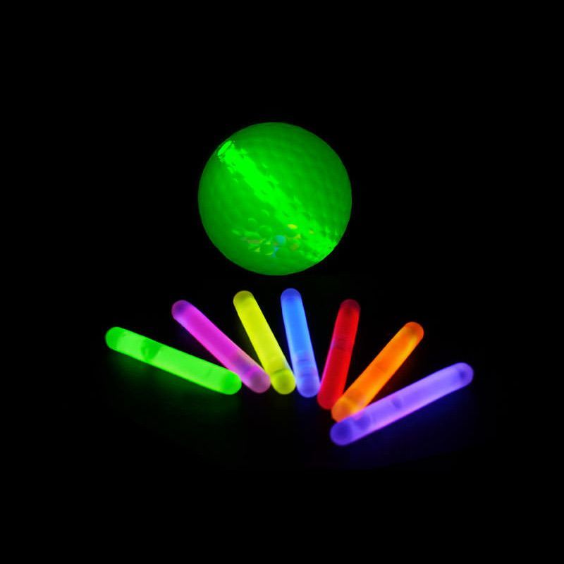 A group of glow sticks in front of a green ball.