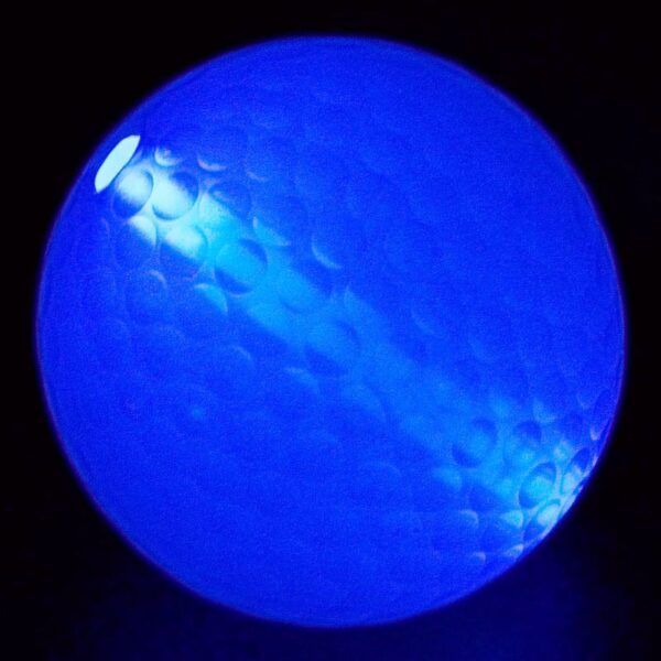 A blue ball is lit up in the dark.