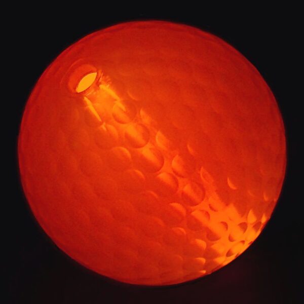 A close up of an orange ball with the light shining on it.