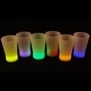 A group of six shot glasses that are lit up.
