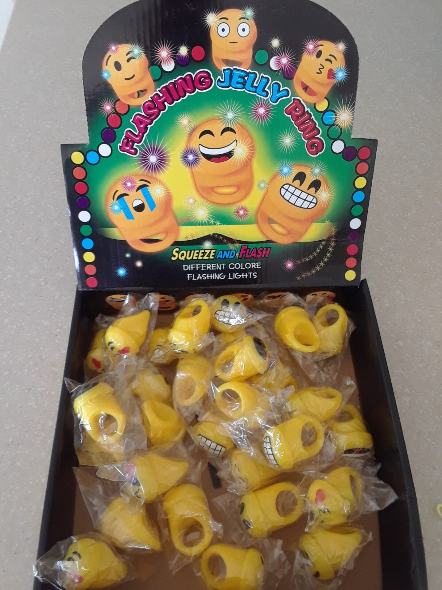 A box of yellow candy with a carton of candies in front.