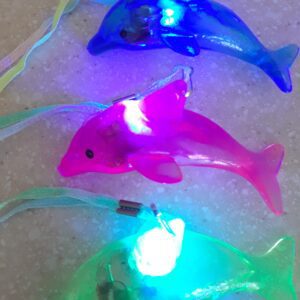 A group of three plastic dolphins with lights on them.