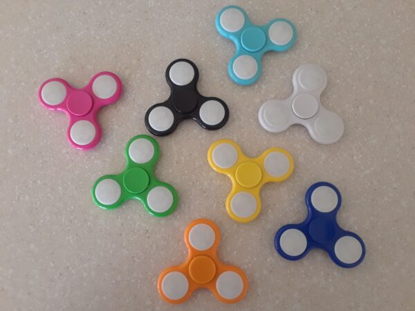 A group of different colored fidget spinners on top of a table.