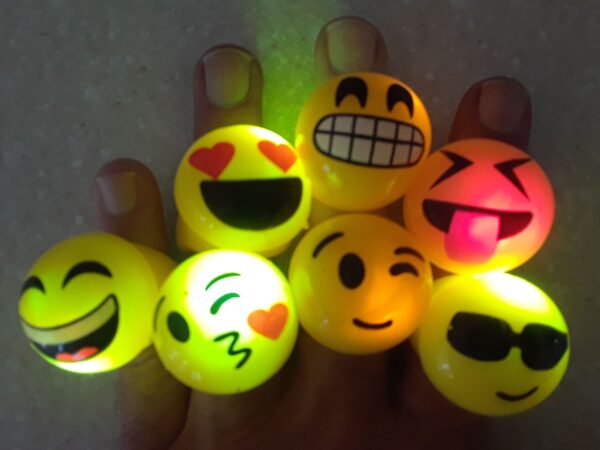 A hand holding some glowing emoticons