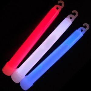 A red, white and blue glow stick on top of a black background.