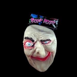 A creepy mask with some candy on top of it.