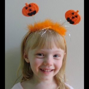 A girl with two pumpkins on her head.