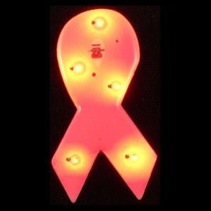 A lighted pink ribbon sign is shown on a black background.