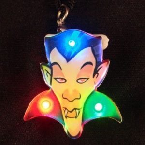 A colorful led light up keychain with a vampire face.