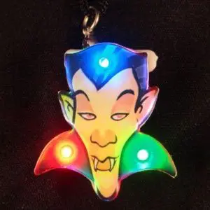 A colorful led light up keychain with a vampire face.